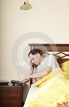 Man in bed calling by phone