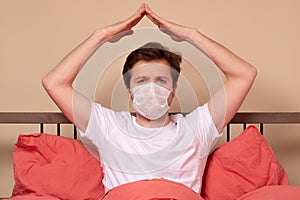 Man in the bed showing roof of house gesture meaning coronavirus quarantine