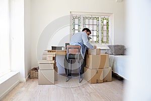 Man In Bedroom Running Business From Home Labeling Goods photo