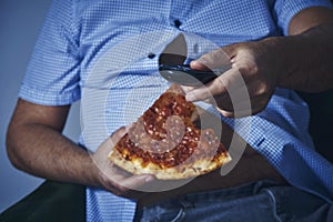 Man with a beer belly eating pizza photo