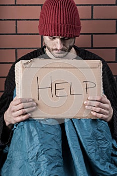 Man begging on the street with help sign