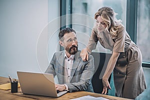 Man behind laptop woman touching his shoulder