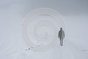 A man from behind walking in snow