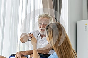 Man being cared for by a private Asian nurse at home suffering from Alzheimer's disease closely care for elderly patients