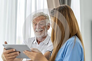 Man being cared for by a private Asian nurse at home suffering from Alzheimer's disease closely care for elderly patients