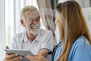 Man being cared for by a private Asian nurse at home suffering from Alzheimer's disease closely care for elderly patients