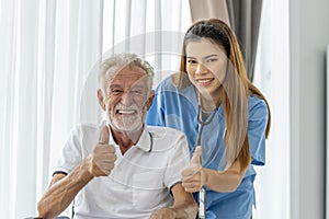 Man being cared for by a private Asian nurse at home suffering from Alzheimer's disease closely care for elderly patients