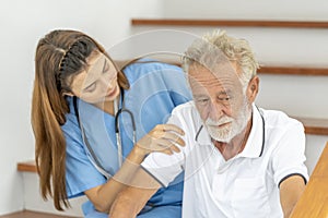 Man being cared for by a private Asian nurse at home suffering from Alzheimer's disease closely care for elderly patients