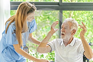 Man being cared for by a private Asian nurse at home suffering from Alzheimer's disease closely care for elderly patients