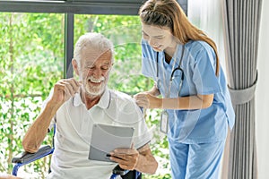 Man being cared for by a private Asian nurse at home suffering from Alzheimer's disease closely care for elderly patients