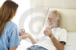 Man being cared for by a private Asian nurse at home suffering from Alzheimer's disease closely care for elderly patients