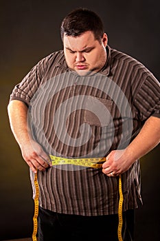 Man belly fat with tape measure weight loss around body .