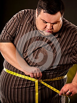 Man belly fat with tape measure weight loss around body.