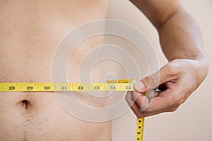 Man with belly and hold Yellow Tape Measure