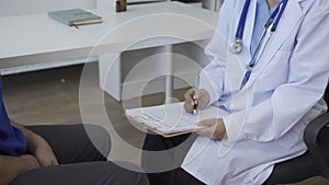 Man with benign prostatic hyperplasia being examined and consulting Asian female doctor