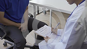 Man with benign prostatic hyperplasia being examined and consulting Asian female doctor