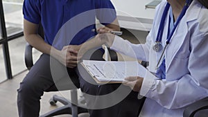 Man with benign prostatic hyperplasia being examined and consulting Asian female doctor