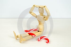 man bent over broken Candy cane in despair. Preparation for Christmas, stress, frustration, failure