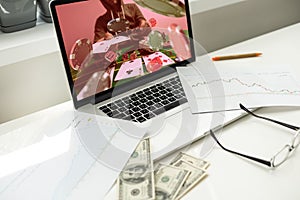 Man betting on sports using laptop at table, closeup. Bookmaker website on screen