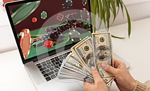 Man betting on sports using laptop at table, closeup. Bookmaker website on screen
