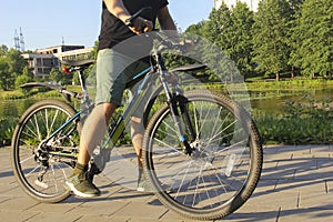 A man on a bicycle. Bicycle wheels close-up. The foot is on the bicycle pedal. Active summer