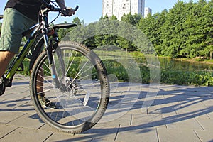 A man on a bicycle. Bicycle wheels close-up. The foot is on the bicycle pedal. Active summer. Blurred focus