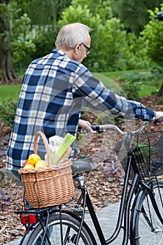 Man on a bicycle is carrying a vegetable basket