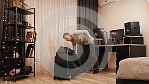 Man with bicycle case at home, preparing to fold bicycle for transportation by airplane. Travel concept. Bicycle trip equipment