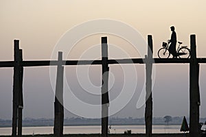 Man with bicycle crossing the U Bein bridge.