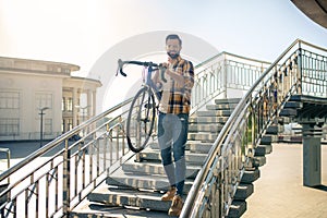 Man with bicycle descending the steps of bridge