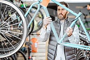 Man with bicycle frame in the store