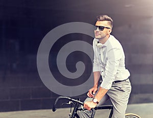 Man with bicycle and headphones on city street