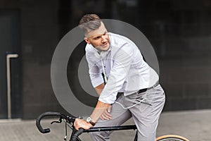 Man with bicycle and headphones on city street