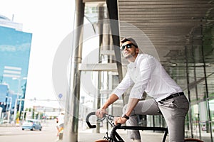 Man with bicycle and headphones on city street