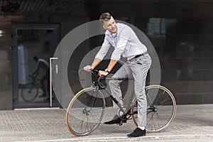 Man with bicycle and headphones on city street