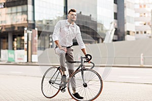 Man with bicycle and headphones on city street