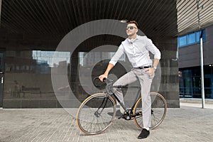 Man with bicycle and headphones on city street