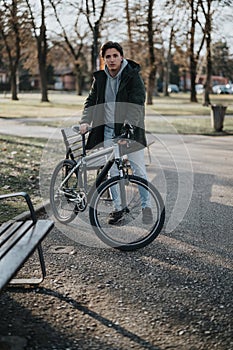 Man with a bicycle in a park on a sunny day, enjoying outdoor activities