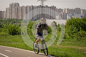 A man on a bicycle is riding on the road in the park