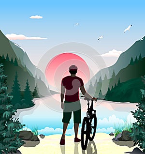 A man with a bicycle on the shore of a mountain lake