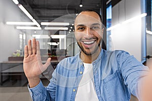 A man with a big smile on his face is waving at the camera