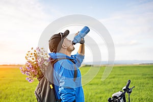 Man with bike drinking water