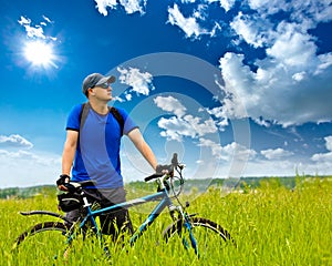 Man with bike on green field