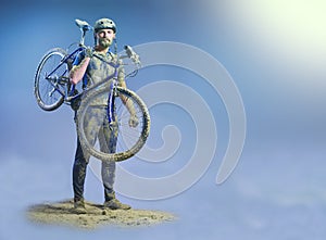 The man with bike in sand standing on abstract background. Collage