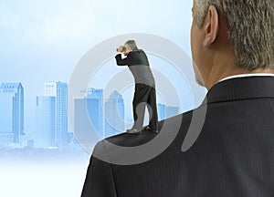 Man with binoculars looking into the distance standing on the shoulders of giants concept with cityscape background