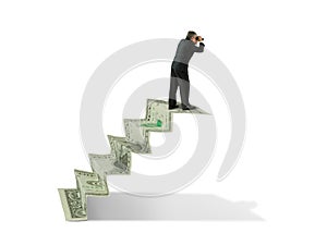 Man w binoculars on money stairs seeking financial success photo