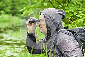 Man with binoculars watching birds