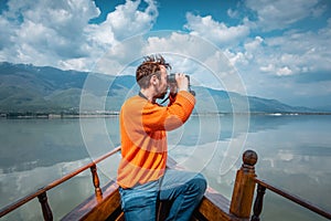 Man birdwatching on a boat