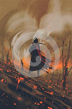 Man in black cloak standing against burning forest