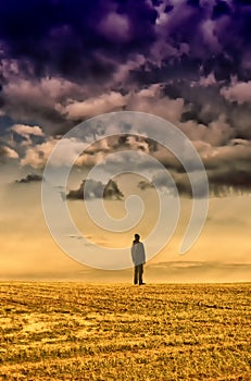 Man in black clothes standing on horizon under datk cloud